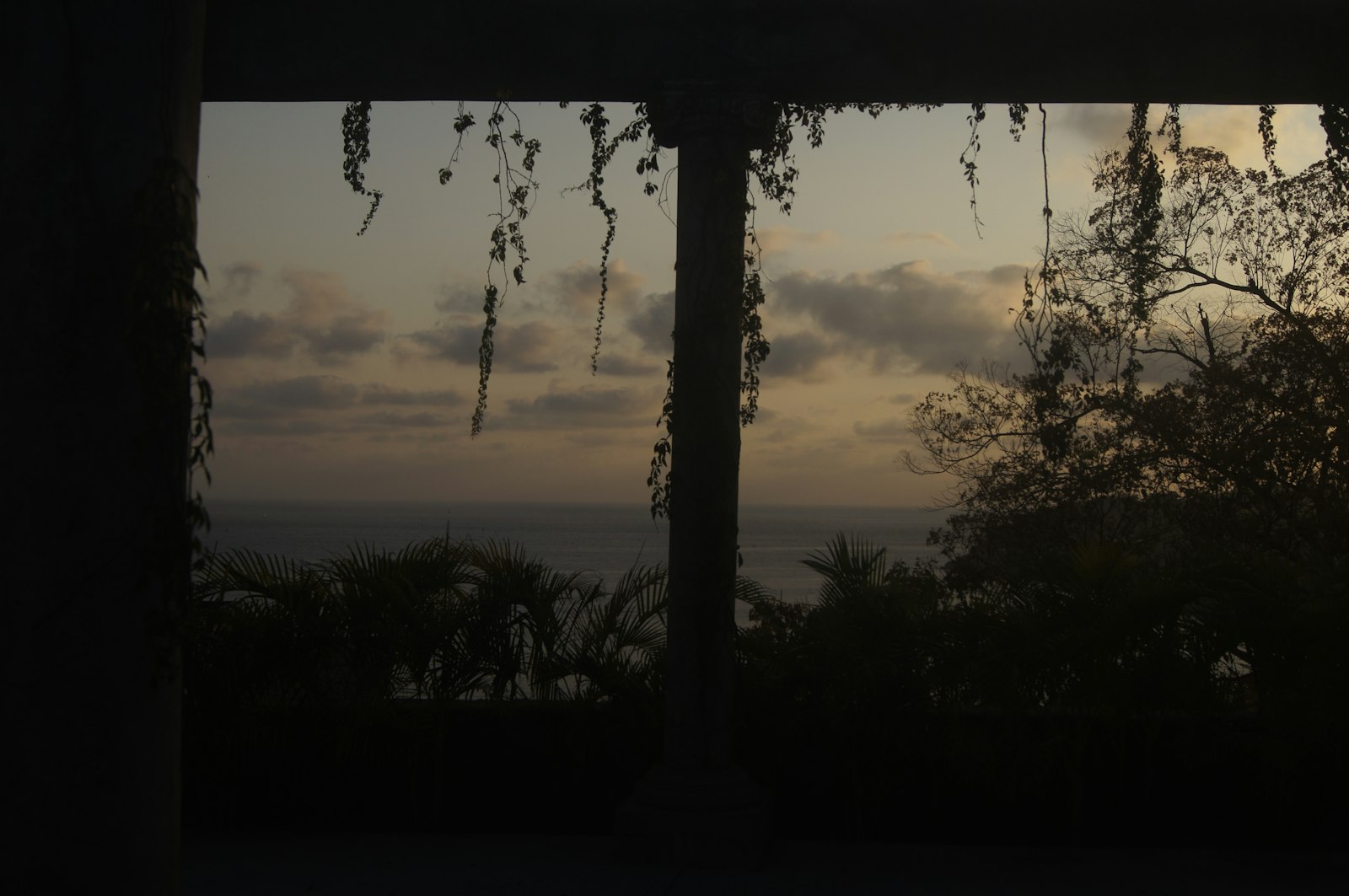 View of ocean and sky through window at dusk