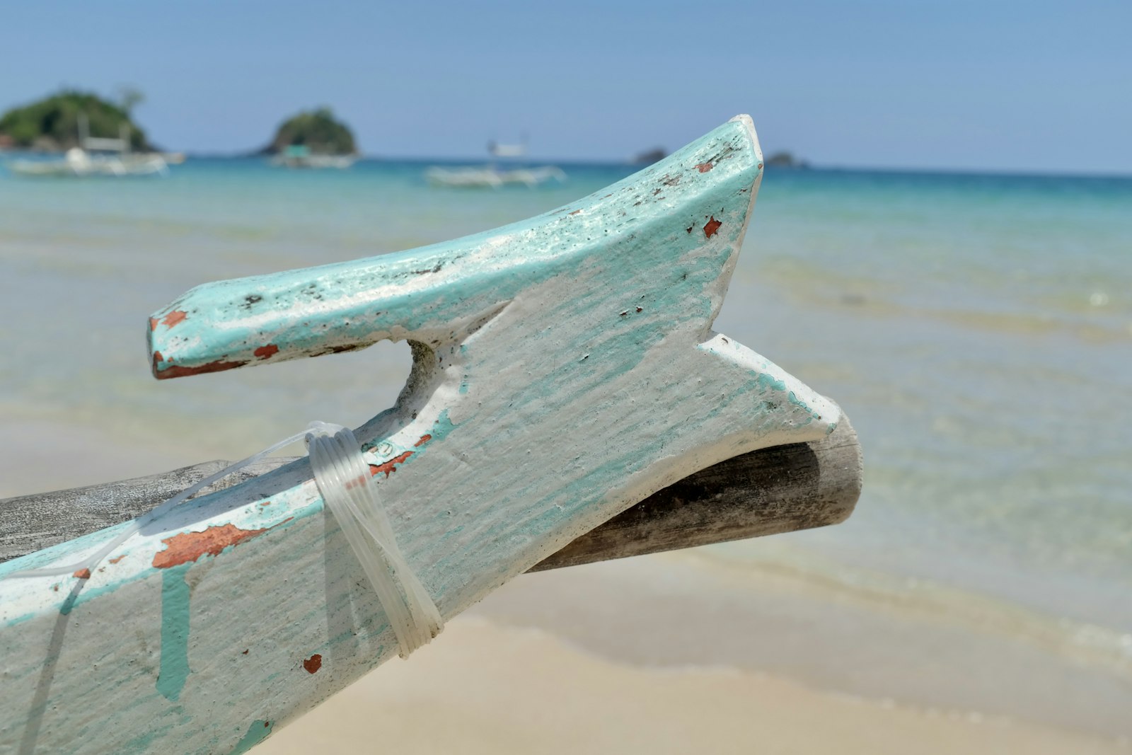 a boat sitting on top of a beach next to the ocean