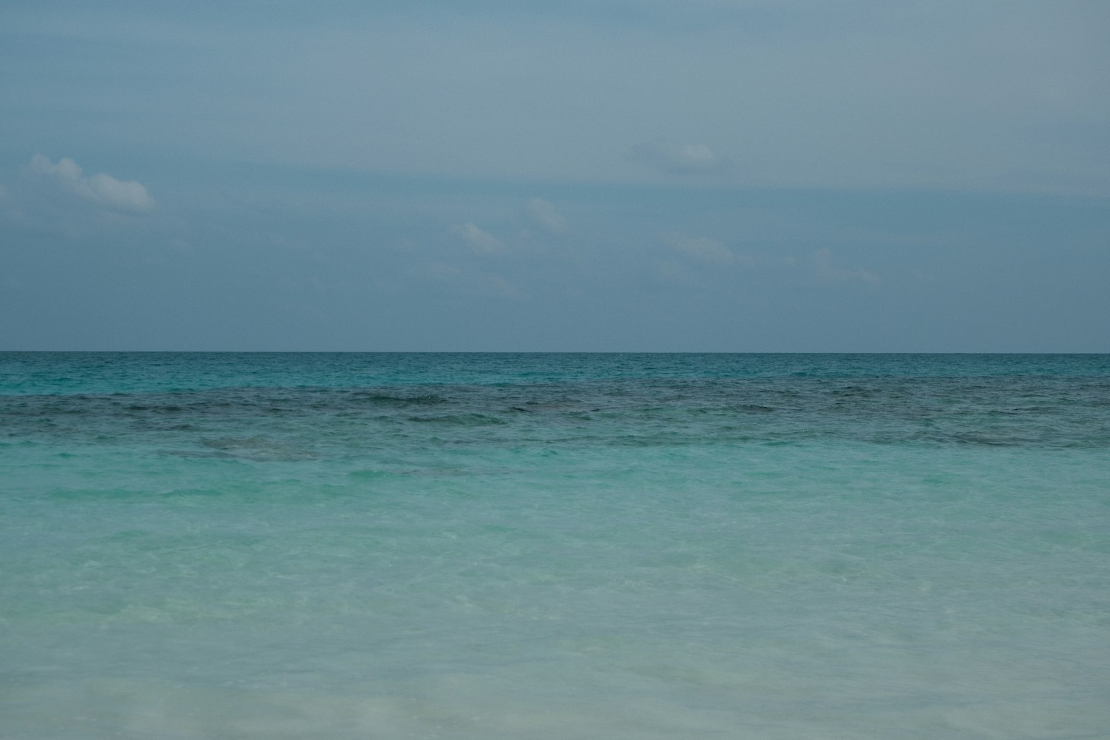 Calm ocean with clear turquoise water and blue sky.
